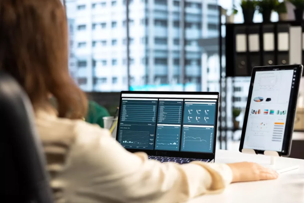 Data-driven decision making with real-time reporting Business analyst reviewing ERP dashboards on multiple screens